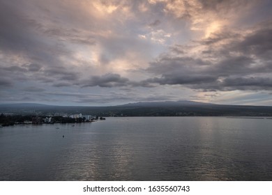 Hilo, Hawaii, USA. - January 14, 2020: Spectacular Lighter Evening Cloudscape With Yellow Sunlight Patches Over Town And Volcano On Horizon.