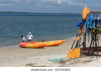 Hilton Head Island, SC USA - Oct 10 2022:  Two Young Boys Explore Orange Kayaks On A Bright Sunny Day With Blue Sky Overhead