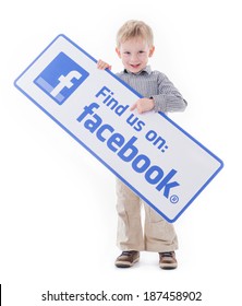 HILVERSUM, NETHERLANDS - APRIL 08, 2014: A Boy Isolated On White Holding A Find Us On Facebook Sign