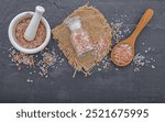 Himalayan pink salt on dark concrete background. Himalayan salt commonly used in cooking and for bath products such as bath salts.