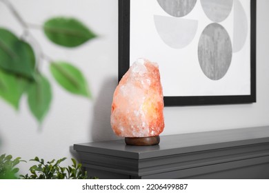 Himalayan Salt Lamp On Grey Console Table Near Wall In Room