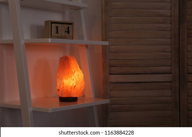 Himalayan Salt Lamp On Shelf In Dark Room