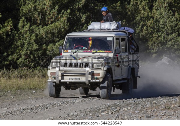 HIMALAYAS, ANNAPURNA REGION, NEPAL - OCTOBER 16,\
2016 : Jeep is the primary means of transport in Himalayas. People\
try to reach their destination, driving through the mountain road\
on trekking path