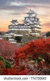 Himeji Castle and red maple leaves in evening sunlight and twilight sky in Himeji city, Japan.