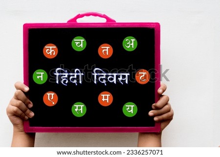 Hindi Diwas means Hindi Language Day word or text written on black chalkboard held with hand in white background.