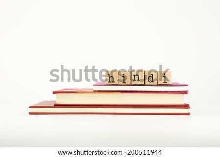 hindi word spelt out on wooden tiles on books, language and study concept.