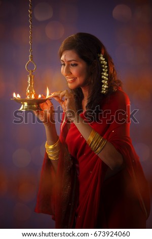 Hindu devotee lights earthen lamps as she celebrate Hindus Diwali Festival , Diwali, known as the 'Festival of Lights,