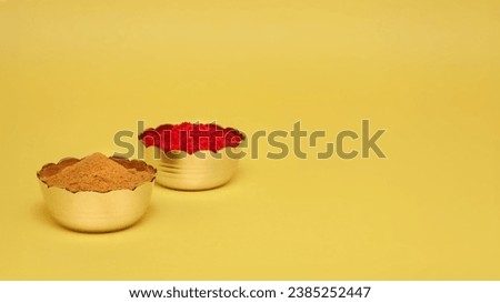 Hindu pooja objects, Auspicious red-colored Sindoor (vermilion) or kumkum, and Haldi in small brass bowls placed over a yellow background. 