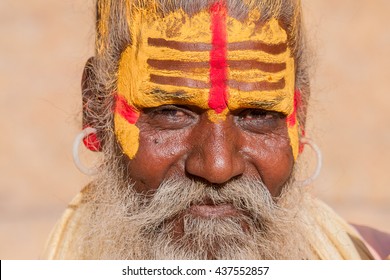 Hindu sadhu holy man, sits on the ghat, seeks alms on the street in Jaisalmer, Rajasthan, India . Close up - Powered by Shutterstock