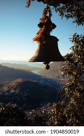 A Hindu Temple Bell With Mountains In Background.