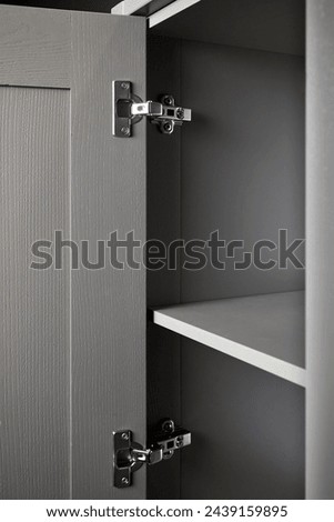 Hinge cabinet of kitchen moss grey cupboard door metal furniture isolated under ash wood countertop tabletop, hardware on wood with copyspace.