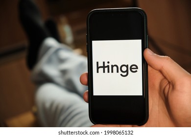 Hinge Logo On The Screen Of Smartphone In Mans Hand Laying On The Sofa. Application For Dating, June 2021, San Francisco, USA
