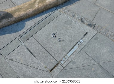 a hinged hatch with a patent lock to the underground of the city, where there are collector shafts with engineering networks. or the facility and subway entrance directly from the sidewalk - Shutterstock ID 2186958501