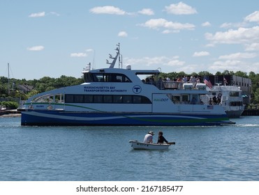 Hingham, Massachusetts, USA - May 29, 2022: A MBTA Commuter Ferry And A Rowboat At Hingham Bay