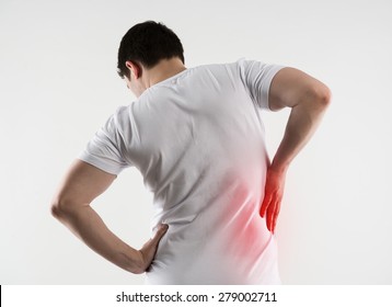 Hip or back injury. Young Caucasian man touching his hurt right side of body. 