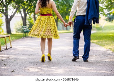 Hip Couple Holding Hands And Walking In A Park