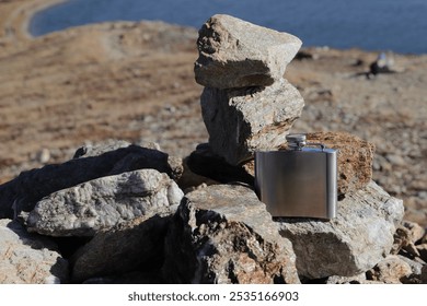 a hip flask while walking on stones