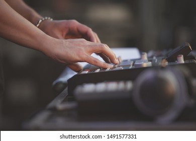Hip hop beat maker playing beats on rap music concert with drum machine.Professional musician plays popular musical tracks on stage with midi controller.Stage audio equipment.EDM dj set in nightclub