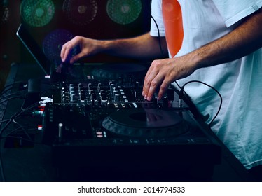 Hip Hop DJ Scratching Music Tracks On Digital  Cd Turntables At Party In Club. Disc Jockey Plays Live Set On Stage Of Music Hall 