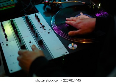 Hip hop dj scratching vinyl record with music on party in night club. Professional disc jockey scratches records on turntables in nightclub. Disk jokey mixing musical tracks on rap concert  - Shutterstock ID 2209814445