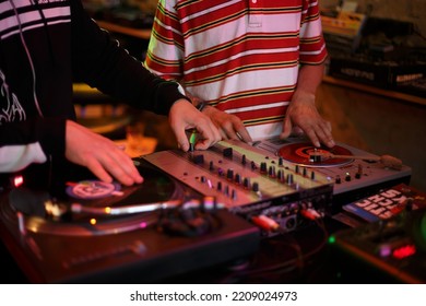 Hip Hop Djs Scratching Vinyl Records On Turntables. Disc Jockey Mixing Musical Tracks On Turntable. Disk Jokey Scratch With Turn Table And Sound Mixer On Party. KYIV - 1 OCTOBER, 2022