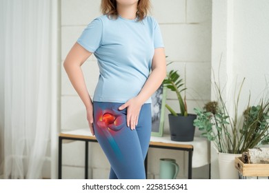 Hip joint pain, woman suffering from osteoarthritis at home, health problems concept - Shutterstock ID 2258156341