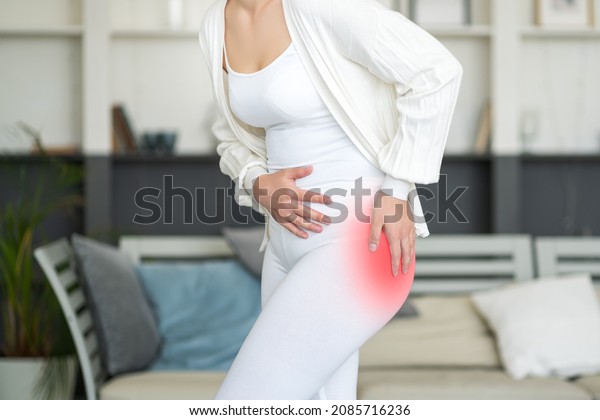 Hip pain, woman suffering from osteoarthritis at\
home, health problems\
concept