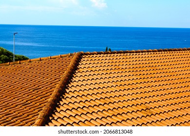 The hip of the pitched tiled roof in orange on the background of the sea