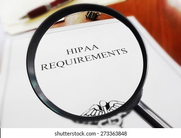 HIPAA healthcare requirements document with magnifying glass                               