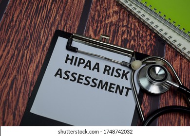 Hipaa Risk Assessment write on paperwork isolated on wooden table.