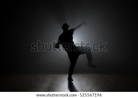 Hip-hop dancer posing backlit.