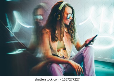 Hip-hop girl with headphones at the neon light. Fashion portrait of modern young woman with phone. - Powered by Shutterstock