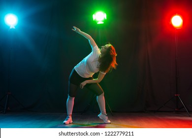Hip-hop, jazz-funk, tecktonik, waacking, trance and street dances concept - Pretty woman dancing jazz funk over dark background