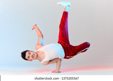 Hip-hop Korean Break Dancer In Red Sweat Pants Stay In White Classroom All Day And Learn Choreography Done By Other People, Working Out Over Technique. BBoy Doing Chair Classic Freeze