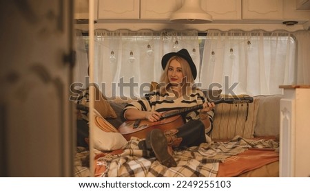 Hippie Boho girl with guitar in trailer, rest relaxing vibe
