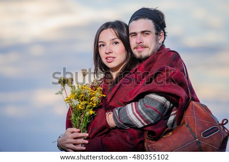Hippie way dressed couple pose in the morning sky background.