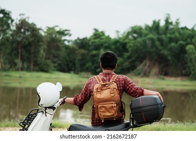 Hipster backpacker riding a motor scooter on road. Travels by scooter slow life on vacation resting time. - Powered by Shutterstock