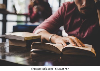 Hipster Bearded Man Reading Book In Cafe.