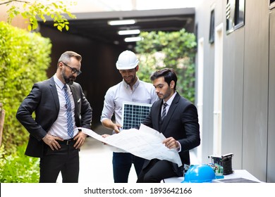Hipster business man and Office building owner and energy engineer plan a project to build a solar panel for the building under construction. clean and green alternative energy concept.