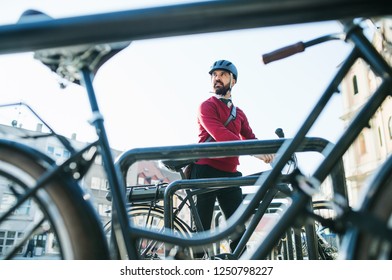 Hipster Businessman Commuter Parking Electric Bicycle In City When Going To Work.