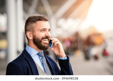 Hipster businessman making phone call waiting at the airport