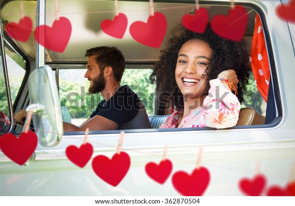 Hipster couple driving in camper van against hearts\
hanging on a line
