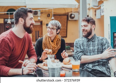 Hipster Friends In Fast Food Restaurant Eating Burgers.