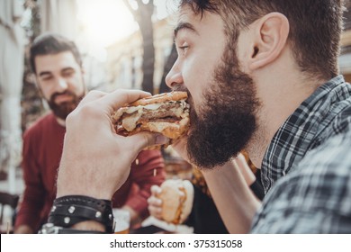 Hipster Friends In Fast Food Restaurant Eating Burgers