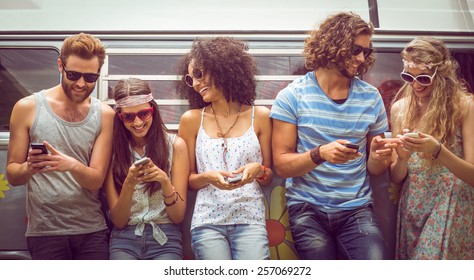 Hipster friends using their phones on a summers day