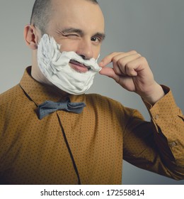 Hipster. Funny Portrait Of Trendy Man Making Moustache And Beard Of Shaving Foam And Gives Wink, Toned.