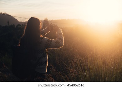 Hipster girl photographer with backpack at sunrise. Explore sunrise, outdoor Bali mountain travel. Travel woman at sunrise. Sunrise girl silhouette. Explore mountain sunset. Travel adventure in Bali - Powered by Shutterstock