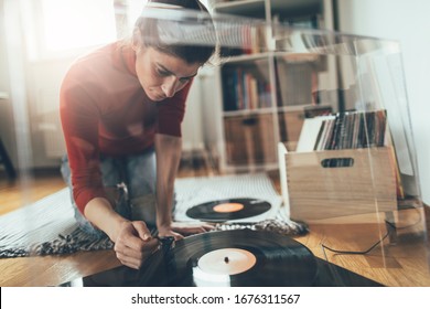 Hipster Girl Playing Vinyl Records On Turntable. Young Audiophile Woman Playing Music At Her Home