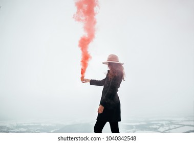 Hipster Girl With Red Smoke Bomb Send Smoke Signal. Emergency Flare Signal