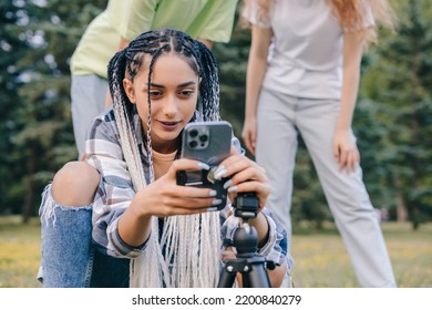 Hipster Girl Trying To Fix The Phone On The Stand Desiring To Take A Self Photo During Joyride. Influencer Filming Video Blog. Young Friends Having Fun